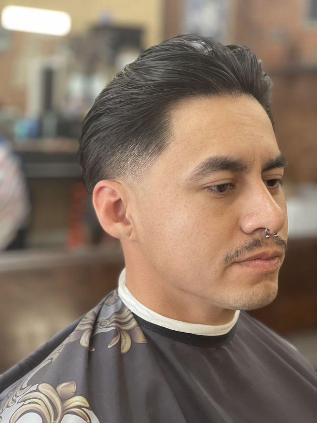 Low taper haircut with slicked-back finish
